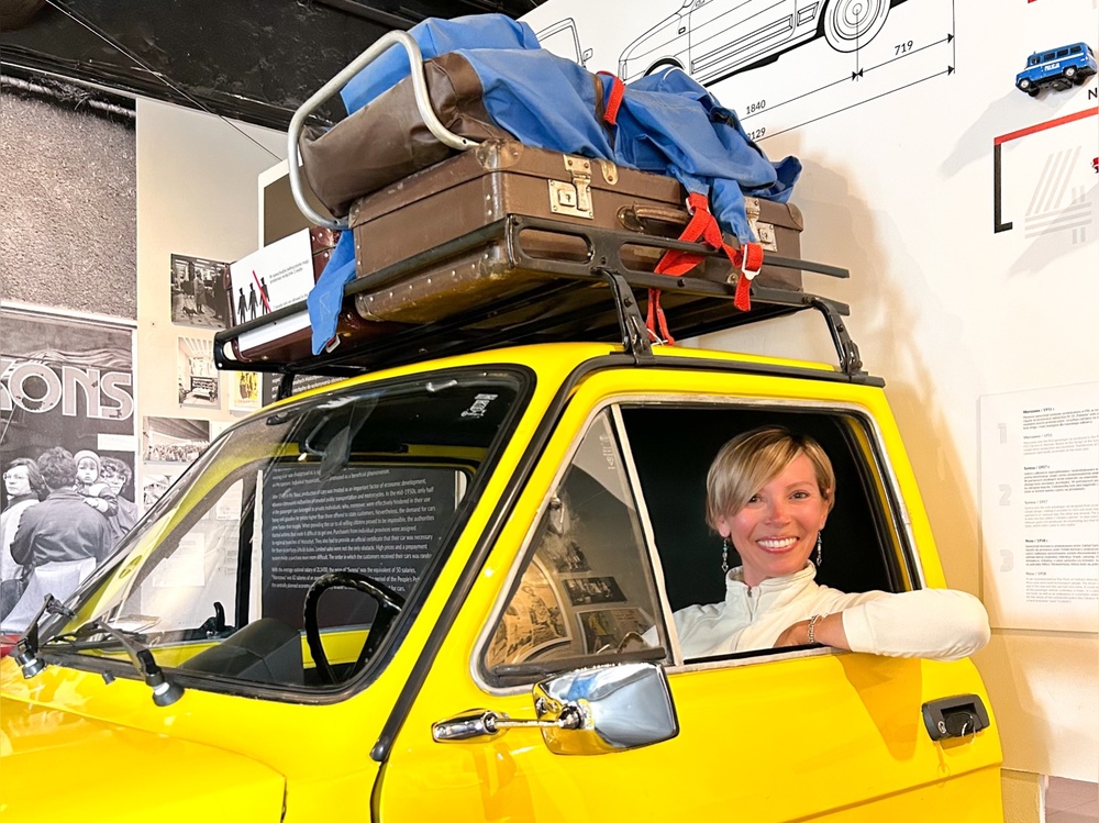 Ragazza all'interno di una Fiat 126 gialla nel museo sotto il regime comunista di Varsavia.