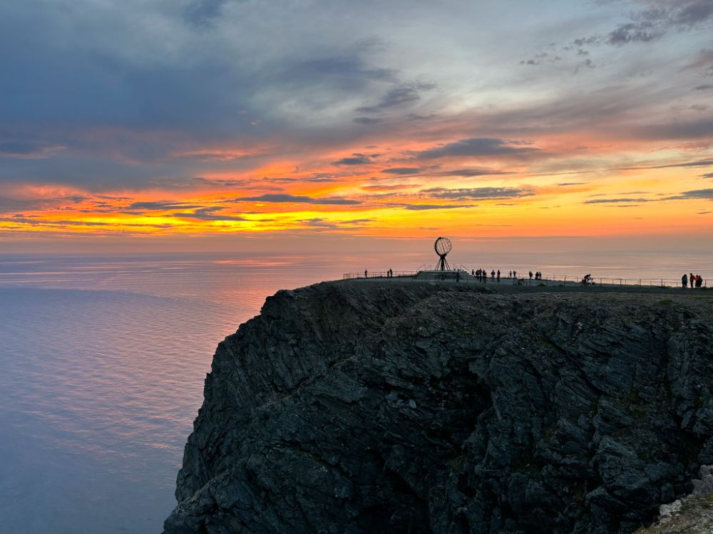 Vista sul mappamondo e la scogliera affacciata sul mare Glaciale durante uno splendido tramonto a mezzanotte in estate