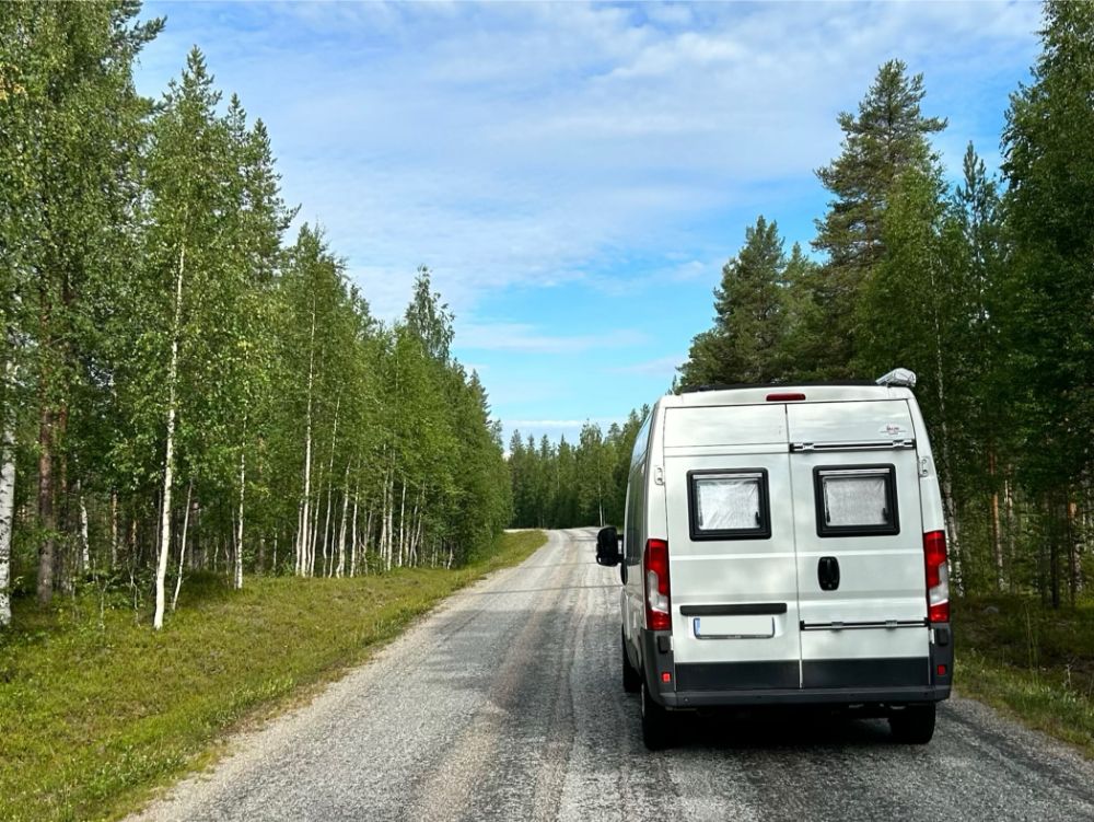 Camper lungo una strada alberata in Finlandia